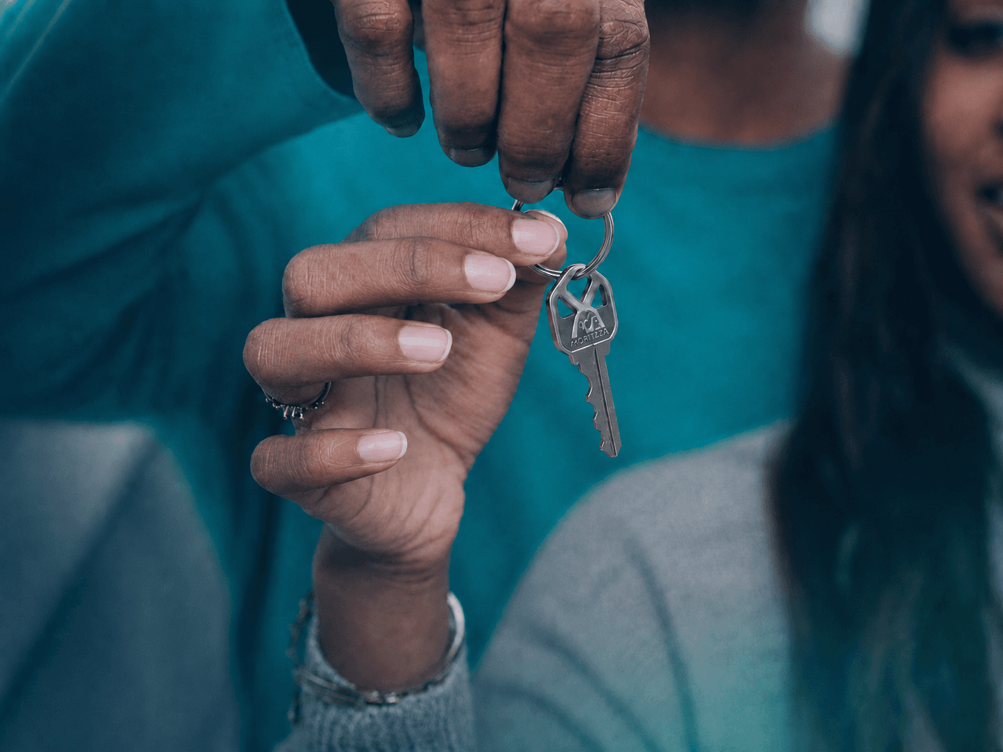 Chave de imóvel entregue em close, com a marca Amortizza